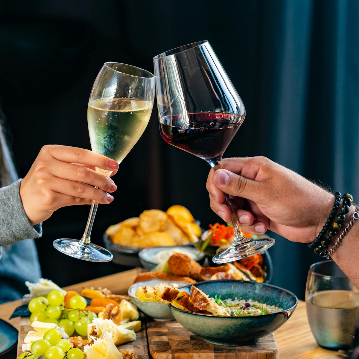 a woman holding a plate of food and a glass of wine