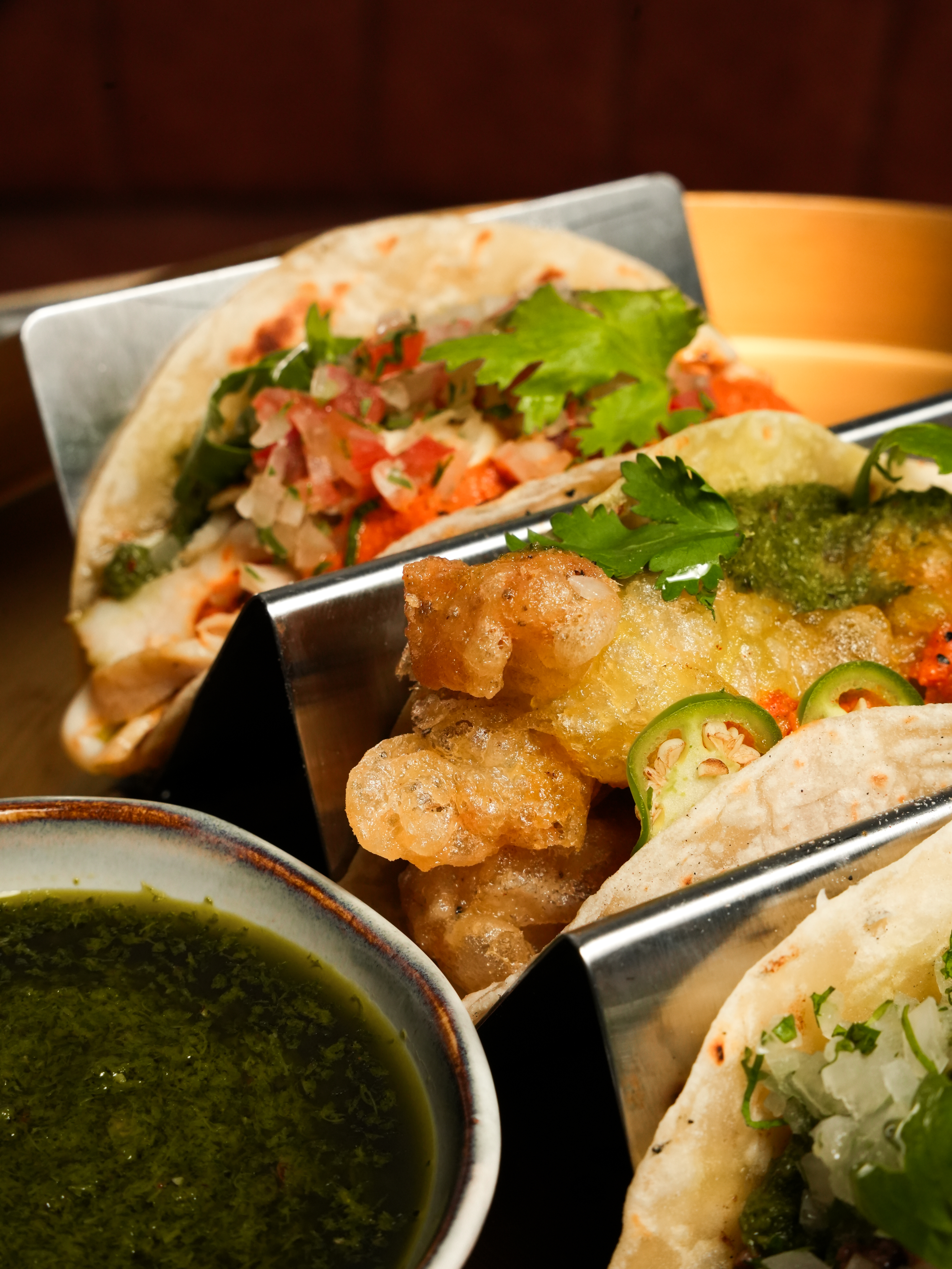 a group of tacos with sauce
