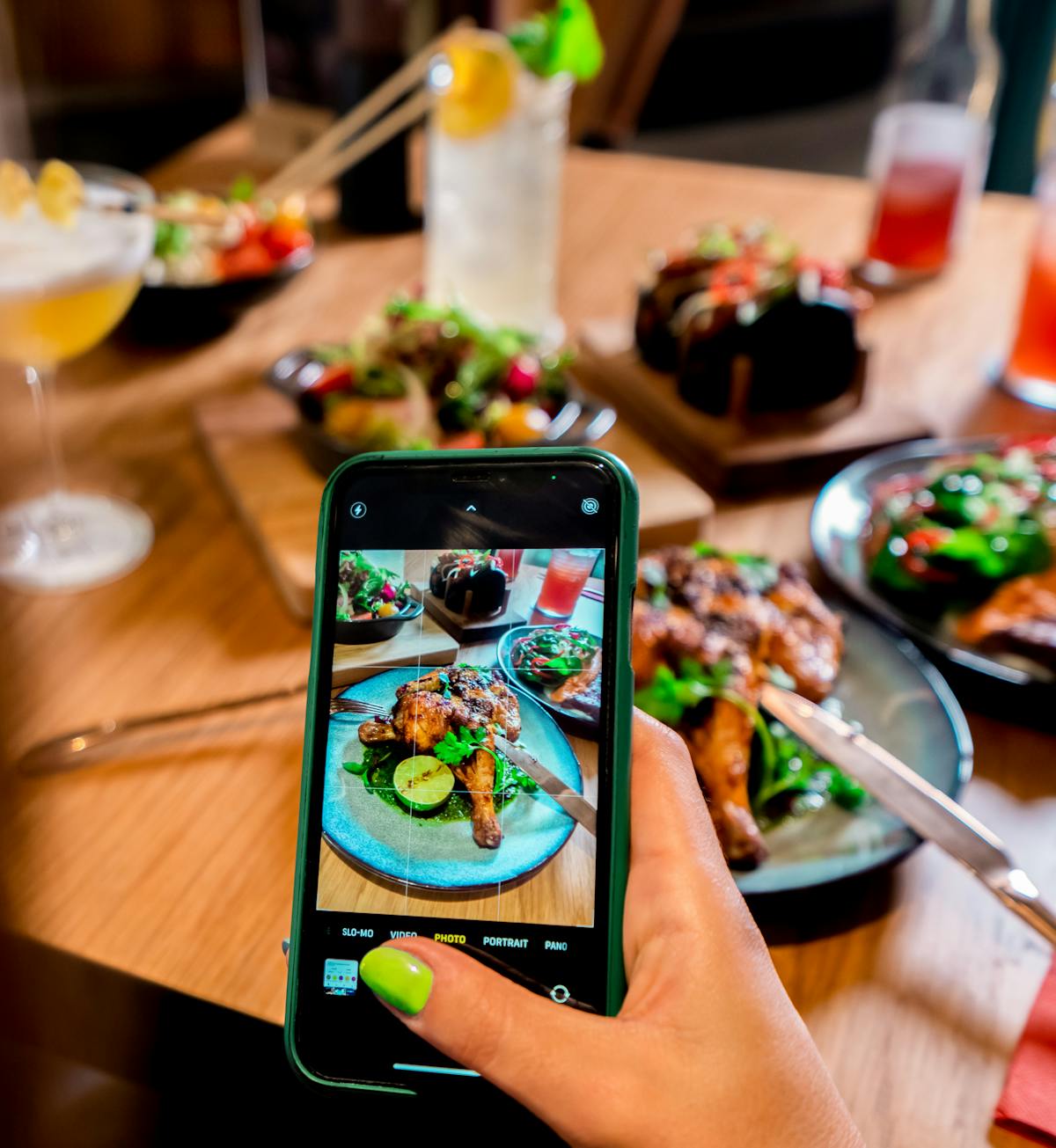 a person holding a plate of food on a table