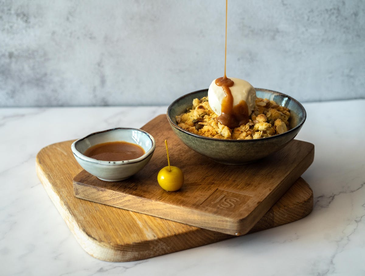 a bowl of fruit sitting on top of a wooden table