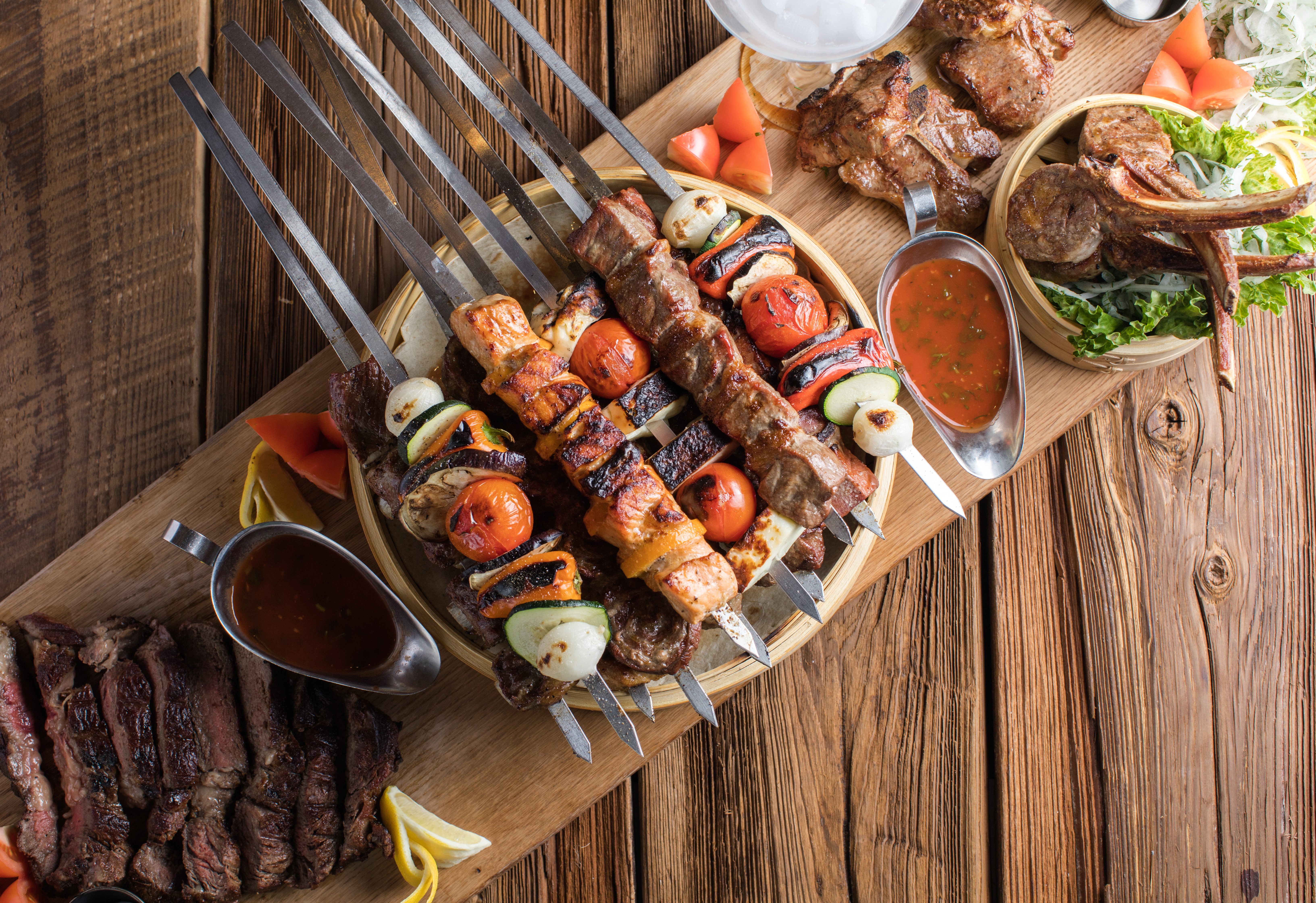 a plate of meat and vegetables on a wooden board