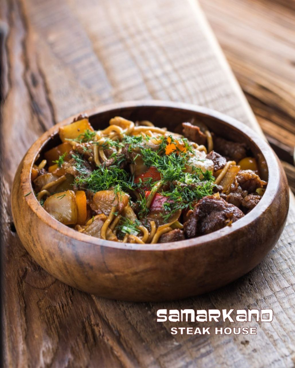 a bowl of food sitting on top of a wooden table