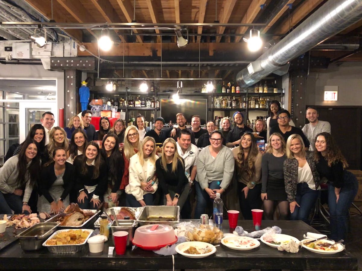 a group of people standing around a table