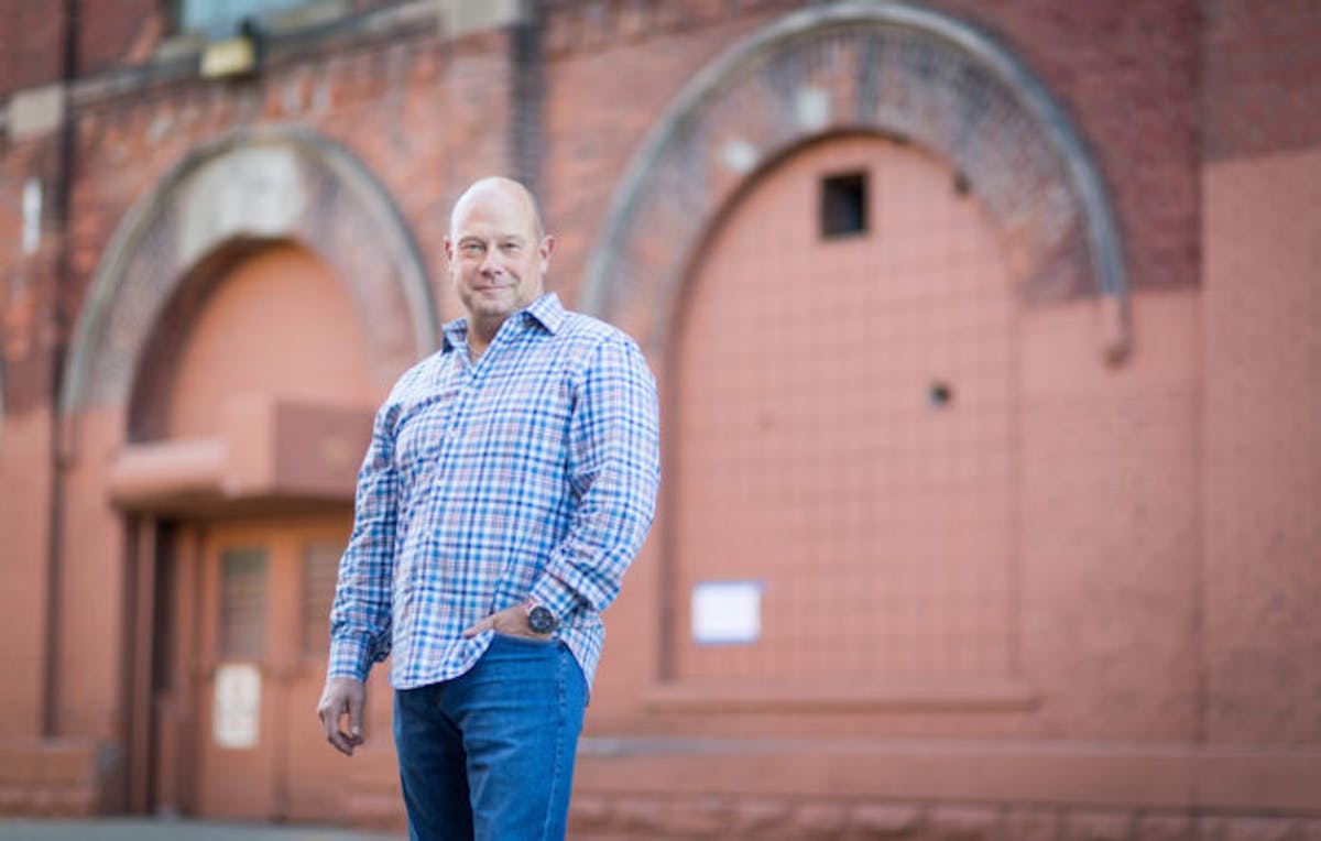 Ieuan Evans standing in front of a brick building