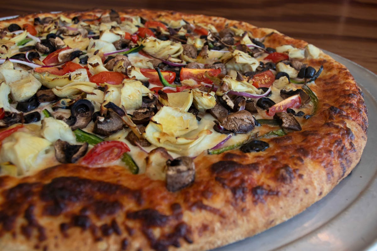 a pizza sitting on top of a wooden table