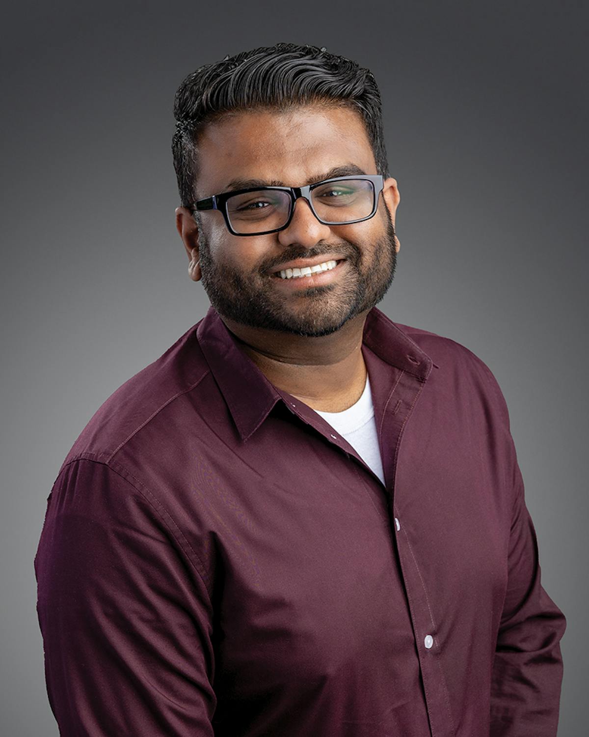 a man wearing glasses and looking at the camera