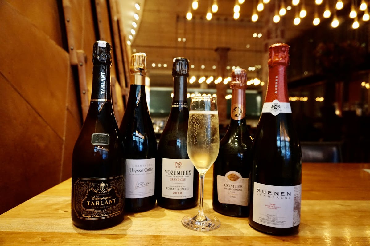 multiple bottles of champagne & one glass