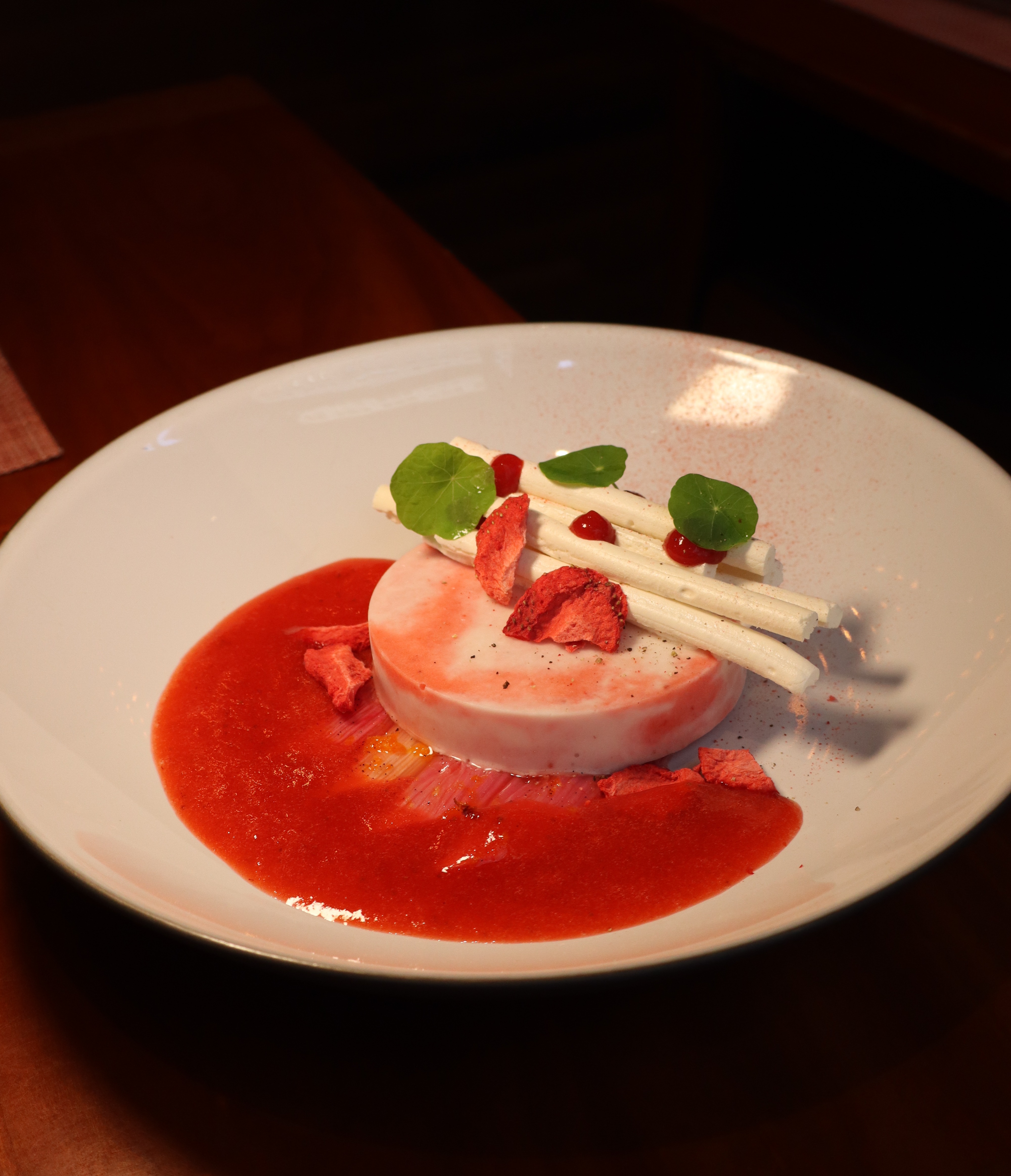 a seasonal Strawberry & Rhubarb dessert on a white plate.
