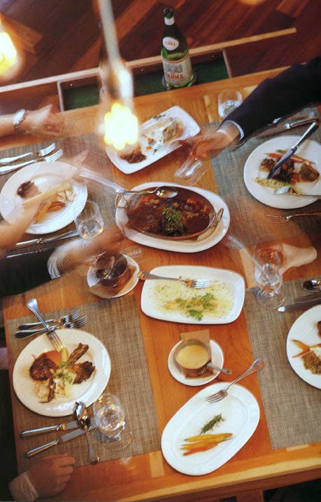 a group of people sitting at a table with a plate of food