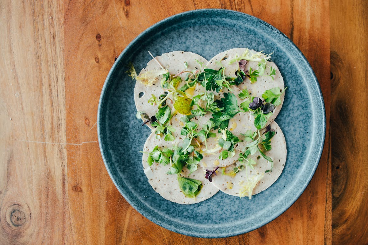 a bowl of food on a plate on a wooden table