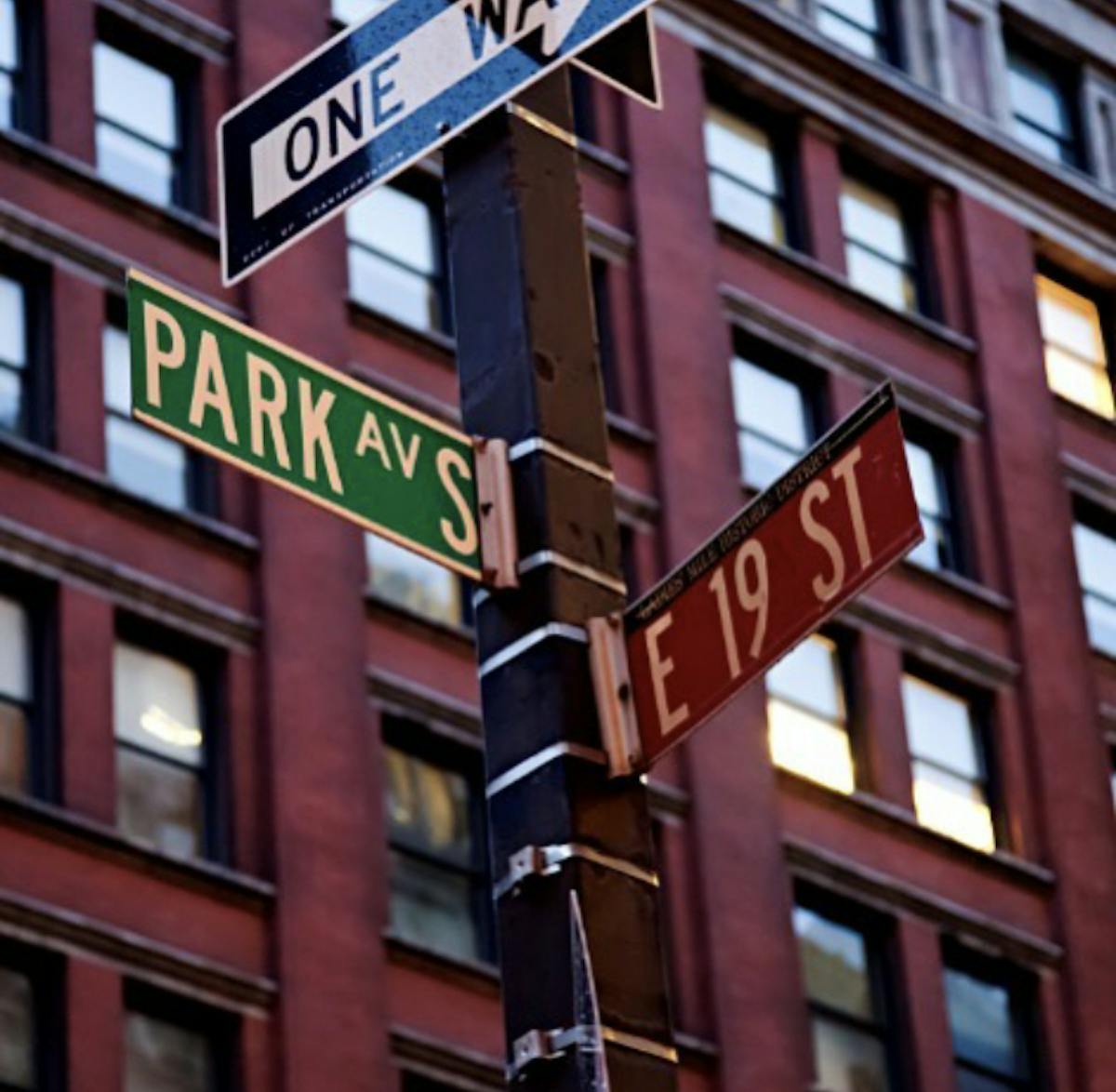 a close up of a street sign in front of a tall building