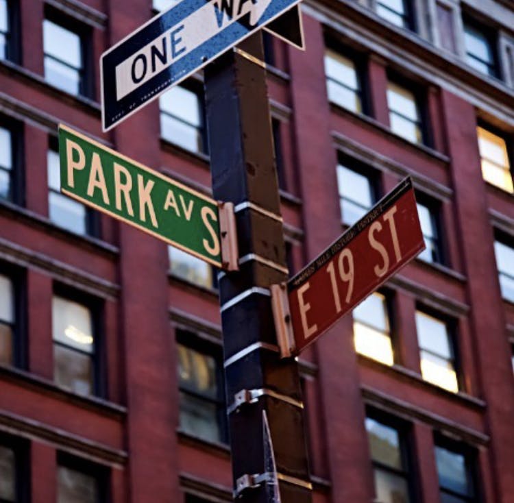 a close up of a street sign in front of a tall building