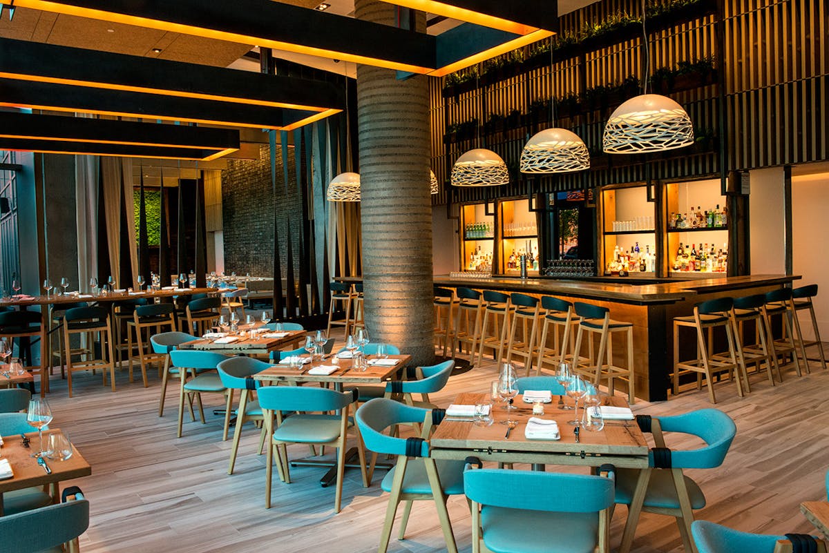 tables with blue chairs next to the bar