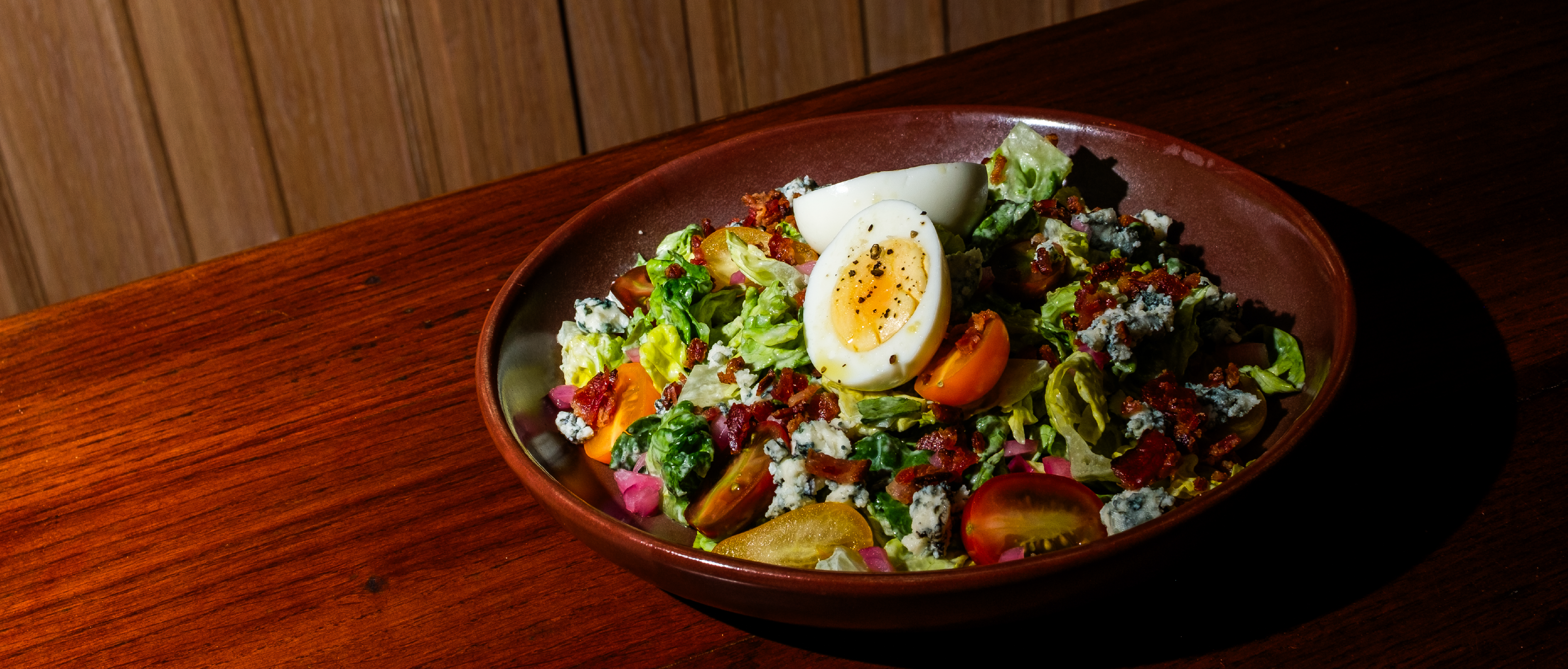 a bowl of salad with eggs and tomatoes