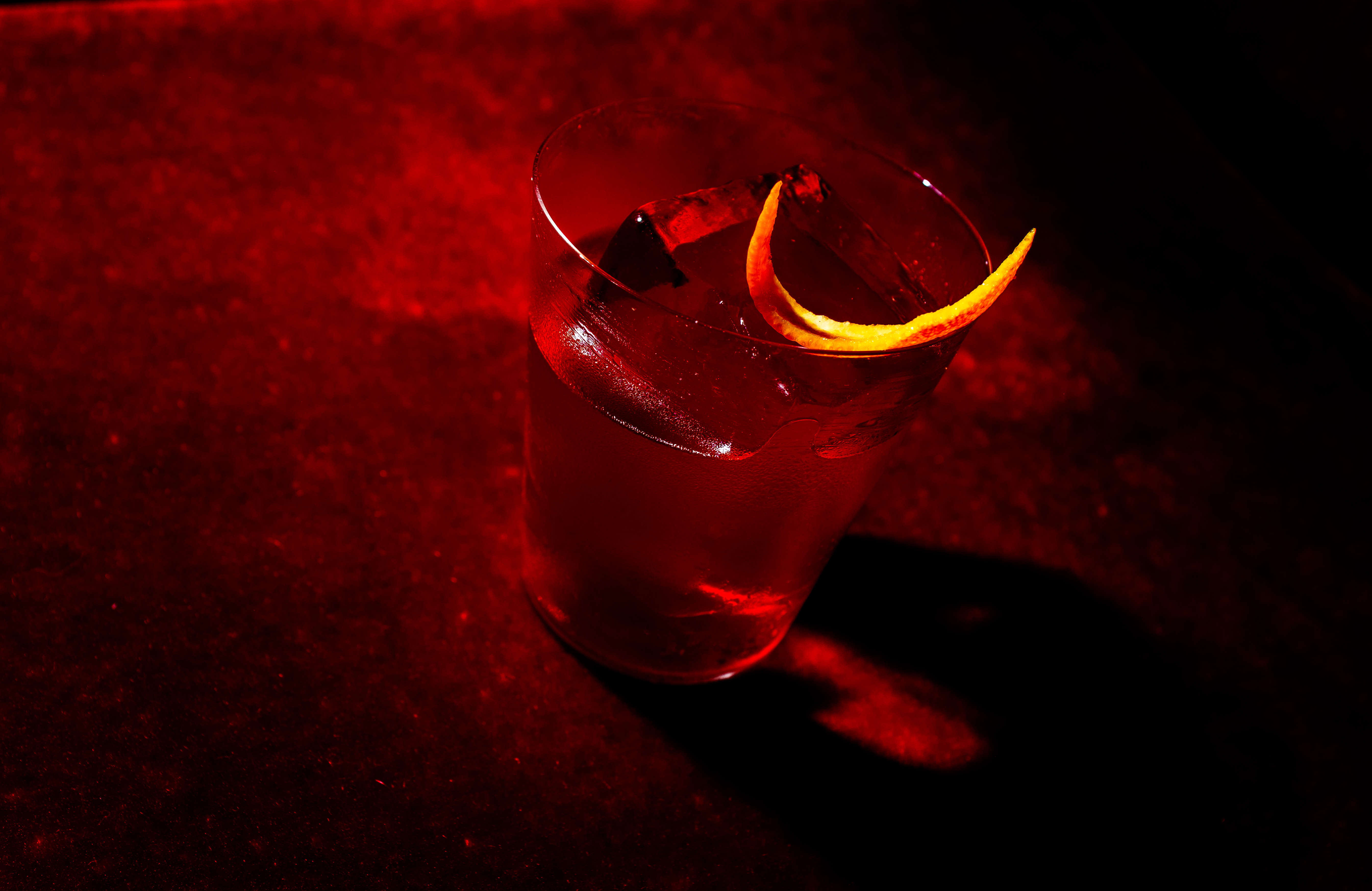 a glass with a drink and a slice of orange peel