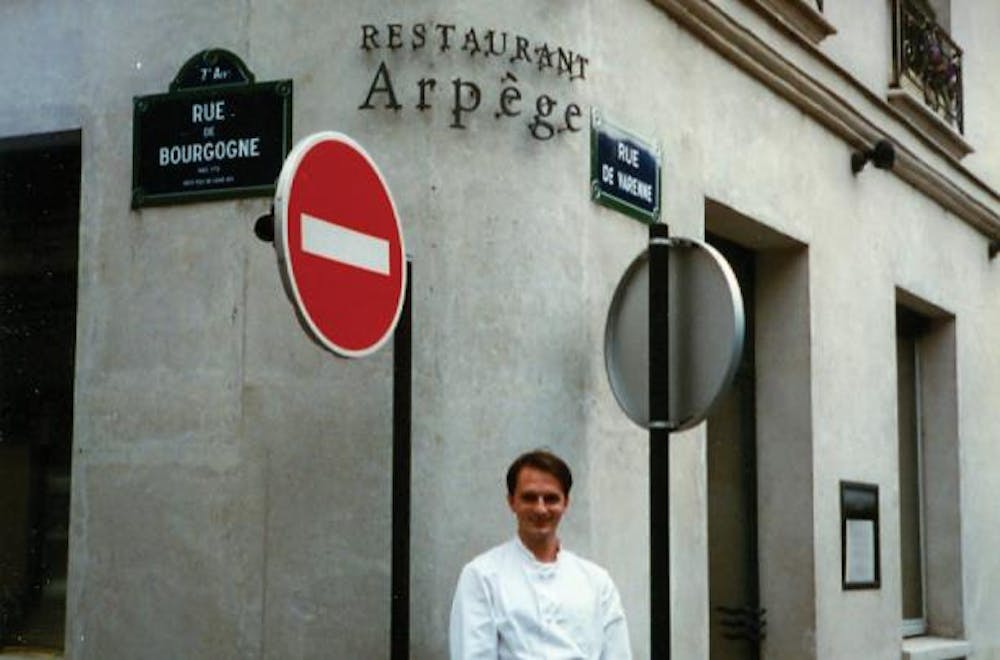 a man standing in front of a sign on the side of a building