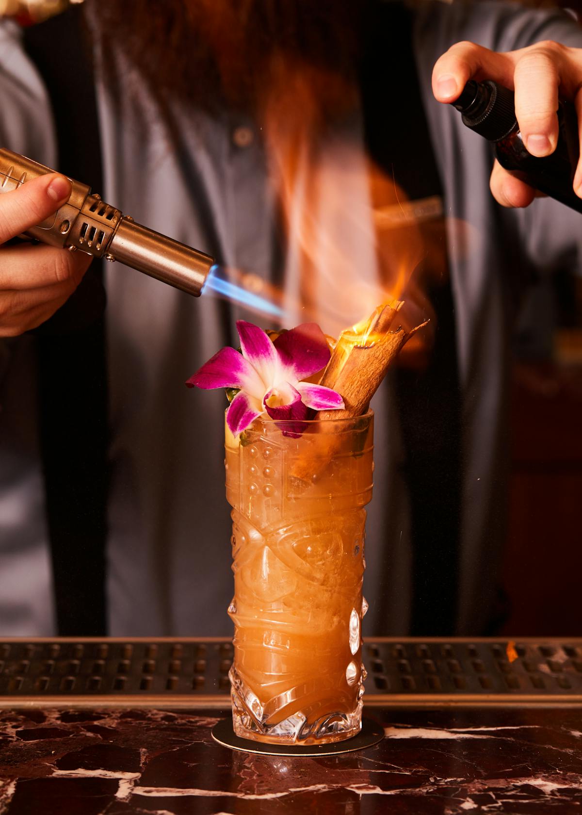 a cocktail being made with a torch