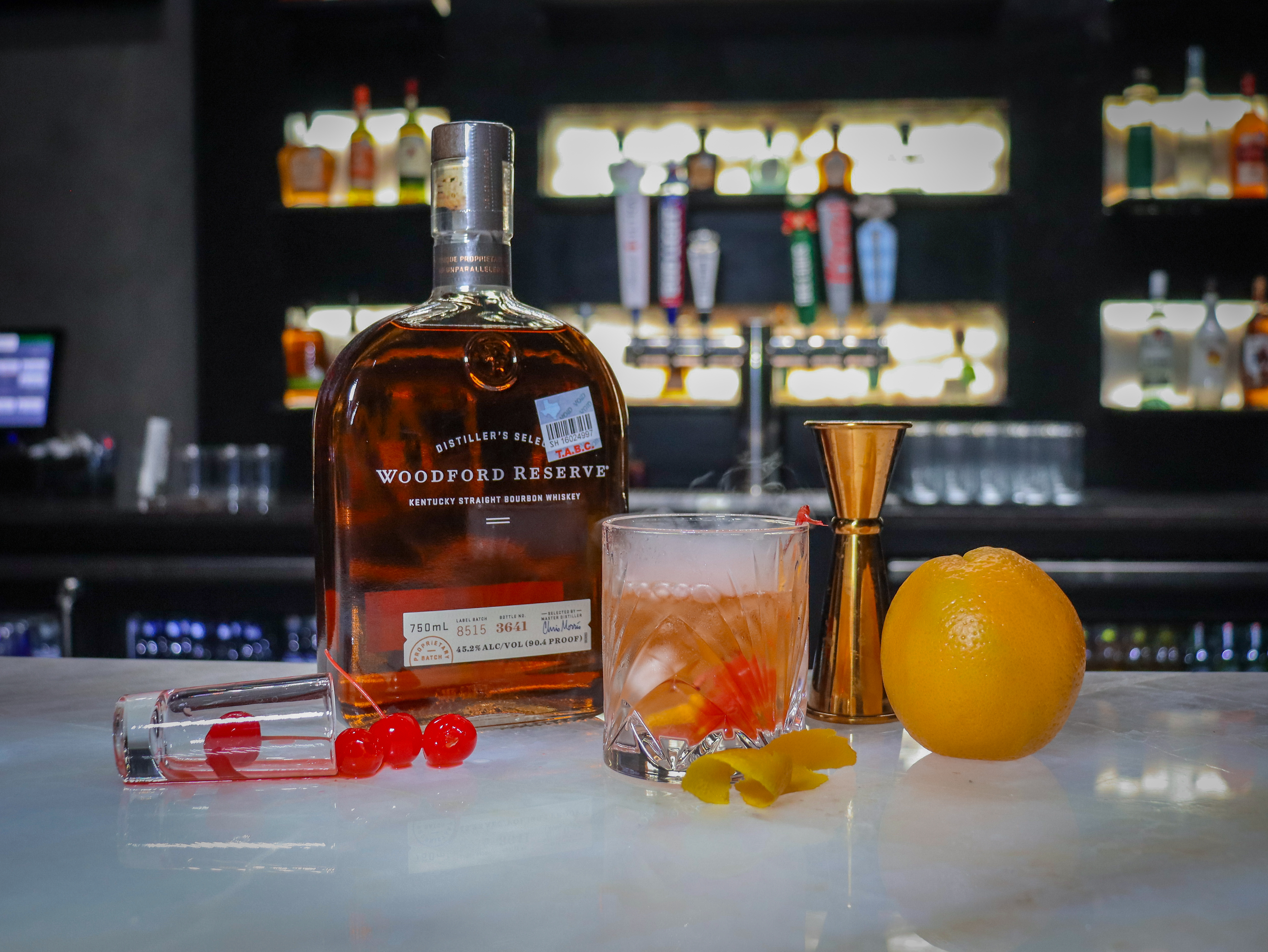 a close up of a bottle and a glass of orange juice