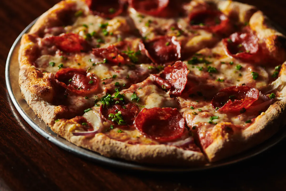 a pizza sitting on top of a wooden table