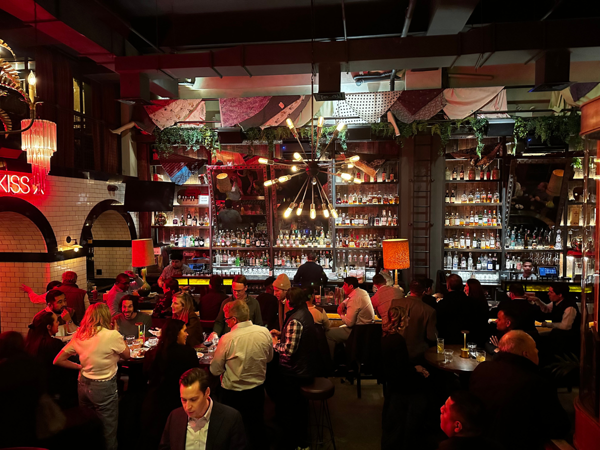 a packed bar with people and drinks