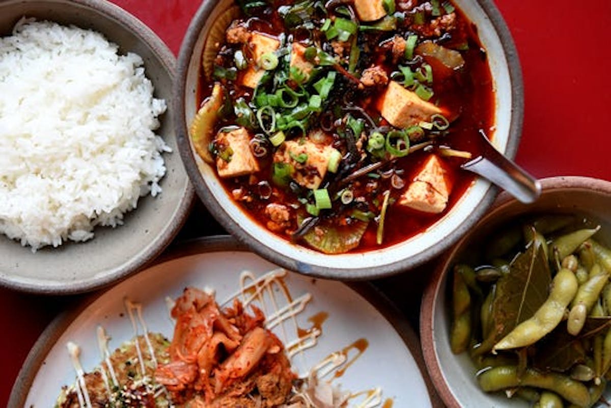 a bowl of food with rice meat and vegetables