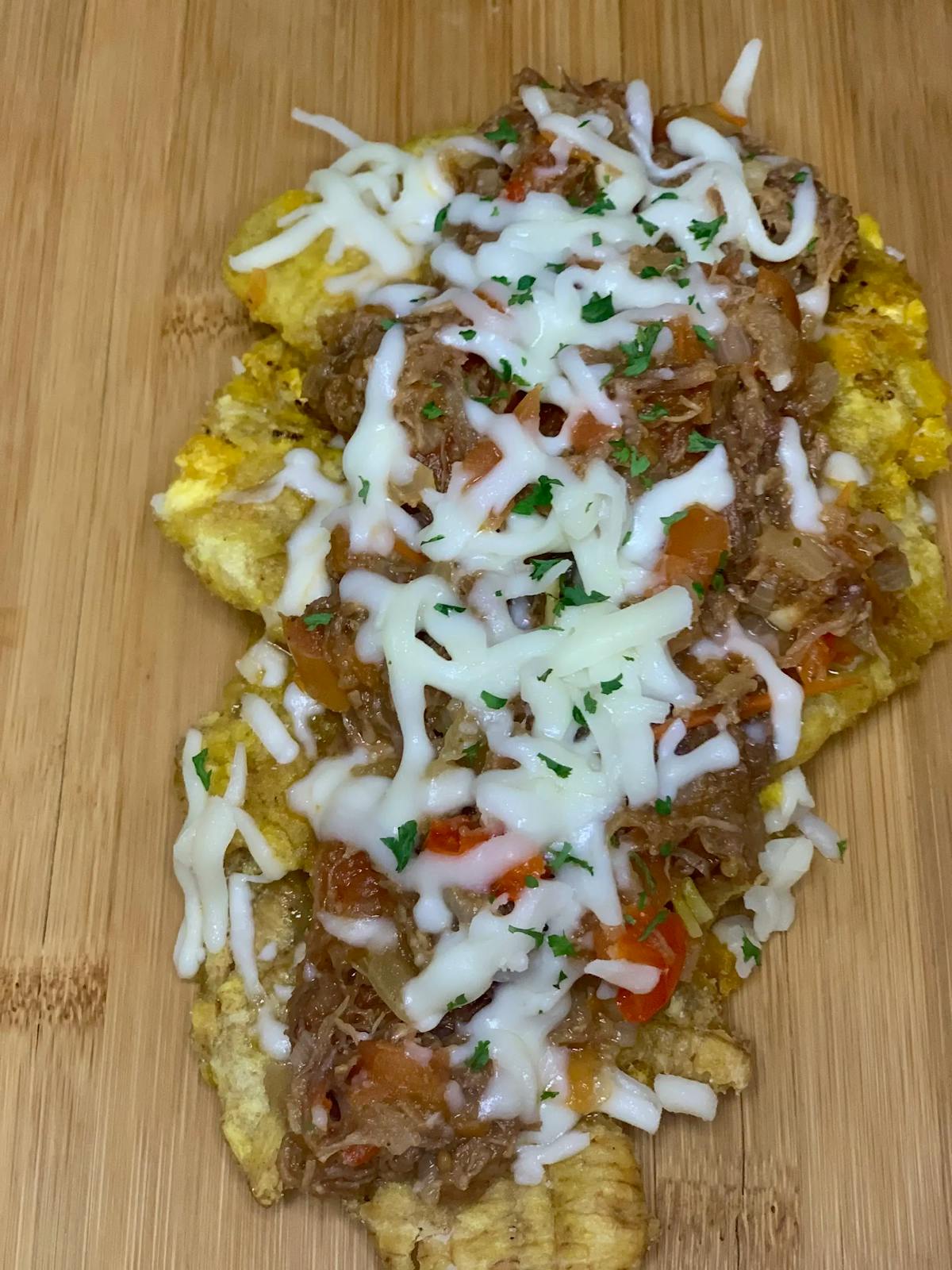 ried smashed plantains with meat and cheese on top