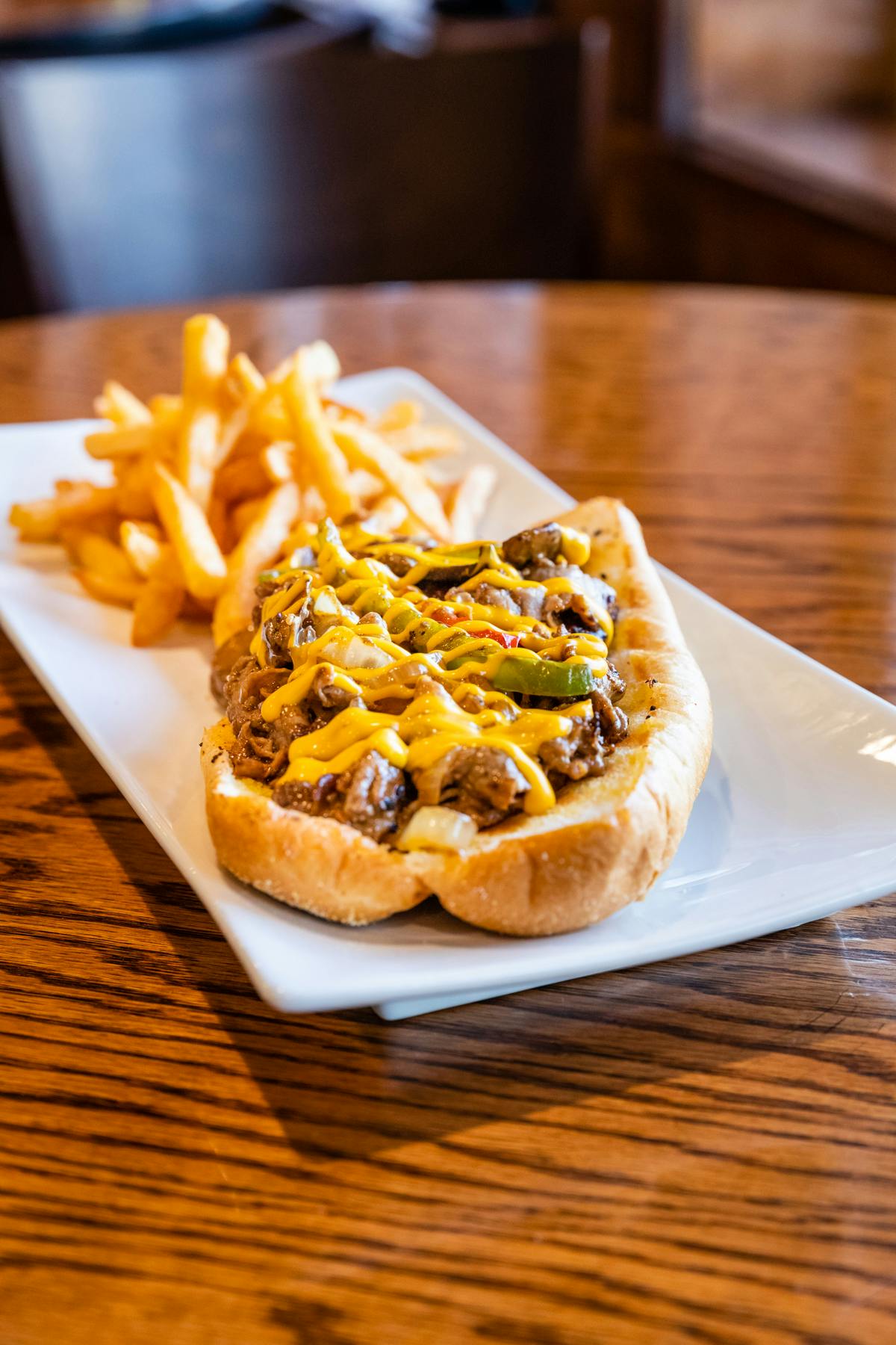 a hot dog with cheese served with fries