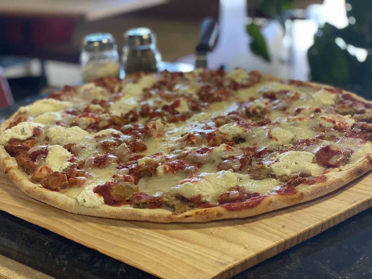 a pizza sitting on top of a wooden cutting board