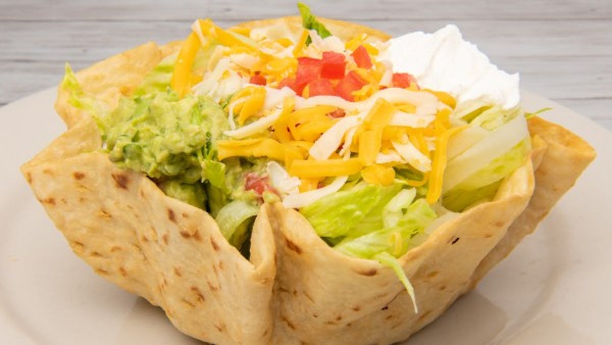 a sandwich sits on a paper plate