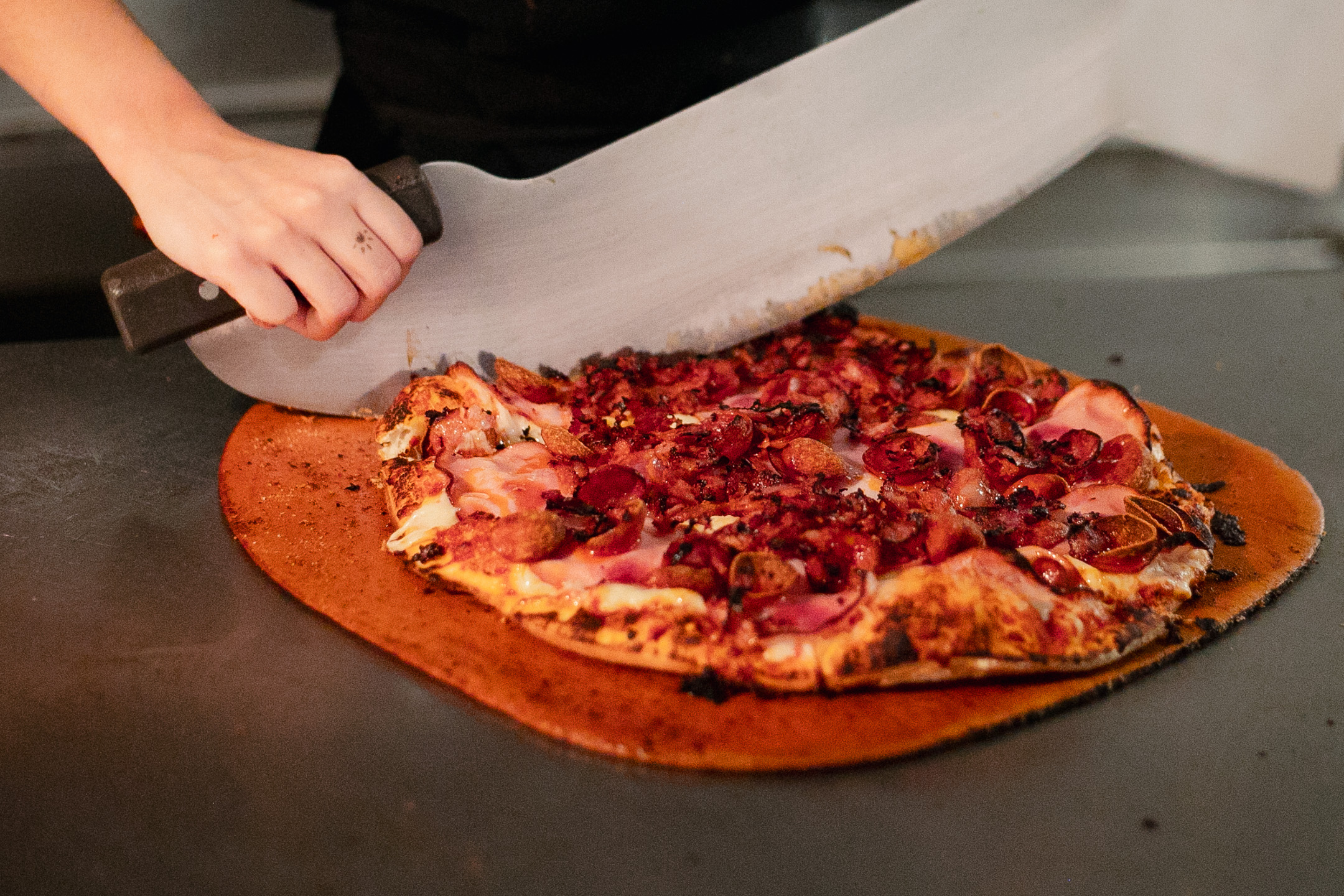 Freshly made Wild River pizza being sliced