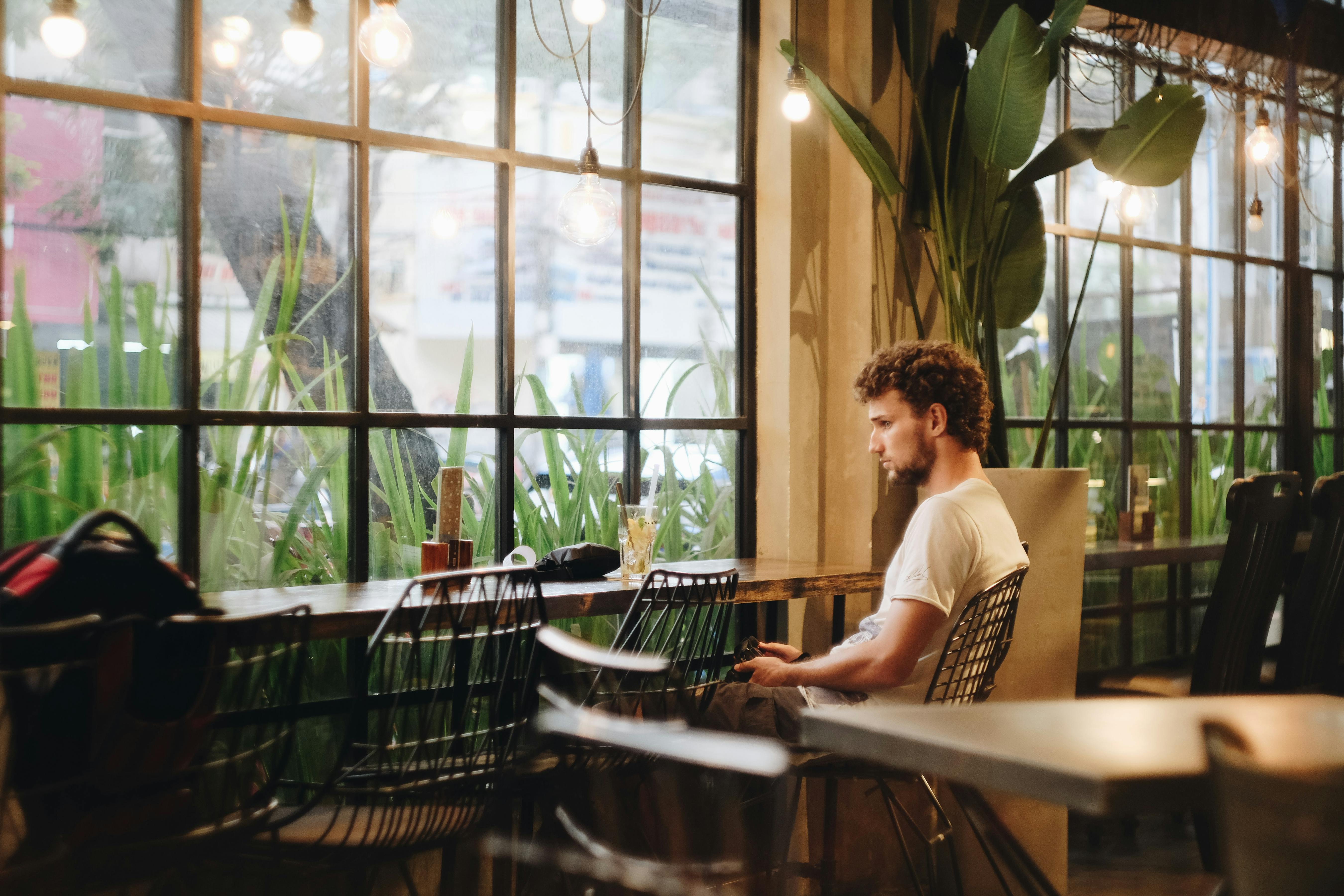 a woman sitting at a table in front of a window