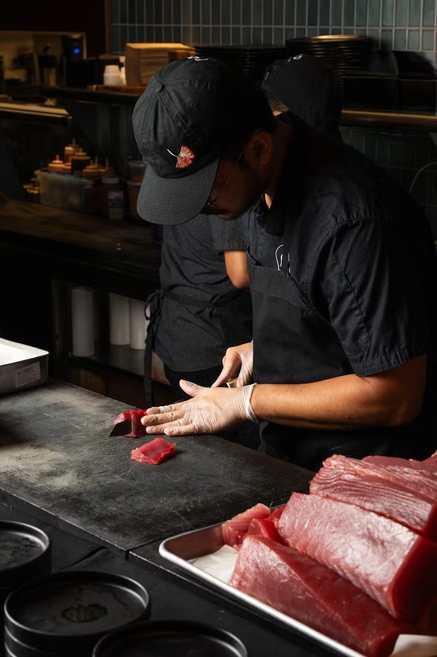 a man cutting raw meat on a counter