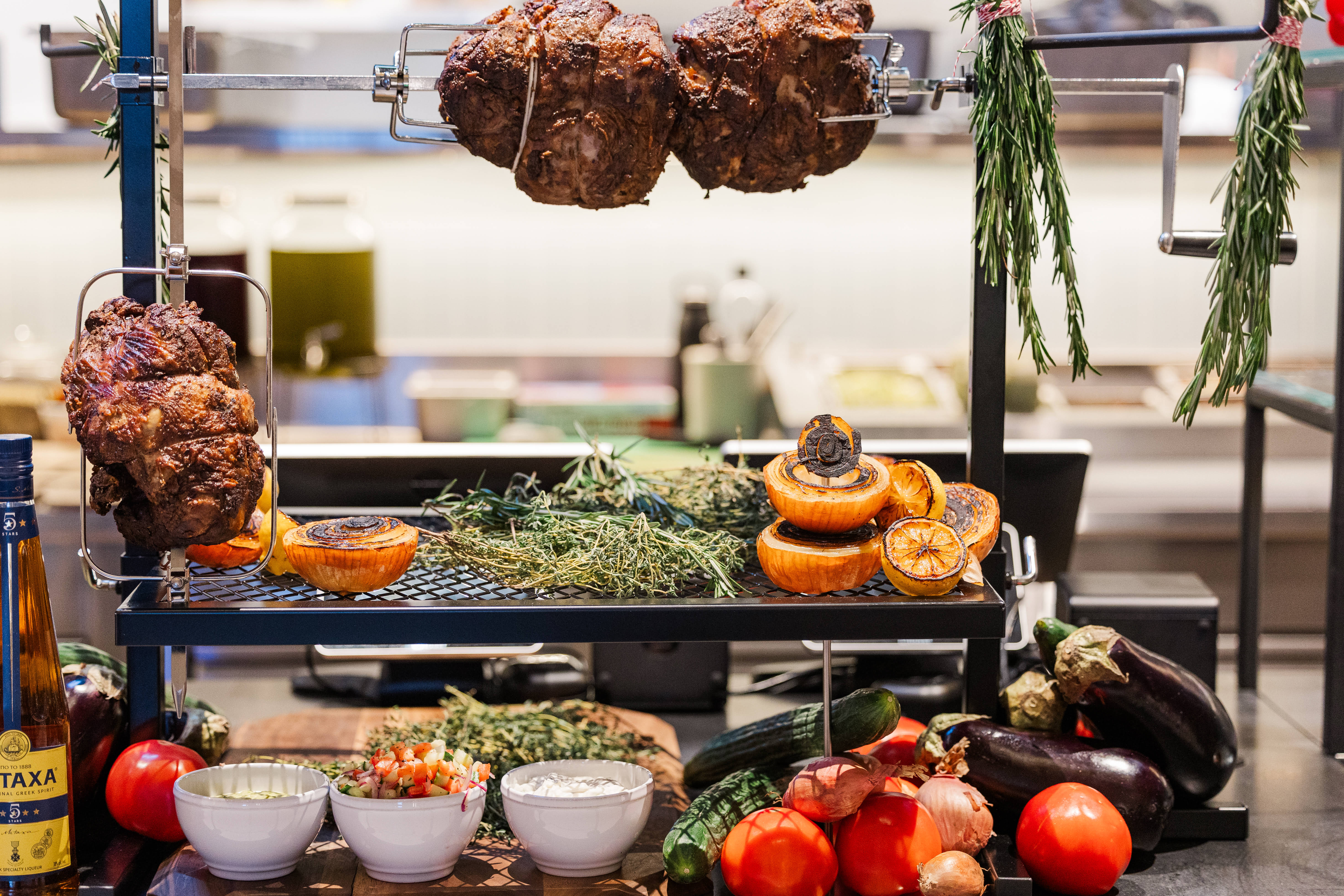 Rotisserie meats roasting with herbs and vegetables at The Lineup, a food hall in one of the best neighborhoods in Boston.