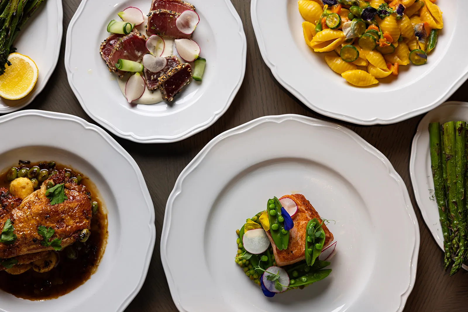 Seared tuna, salmon, pasta, chicken, and asparagus plated for an elegant lunch in Boston.