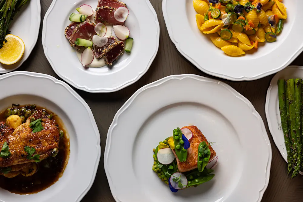 Seared tuna, salmon, pasta, chicken, and asparagus plated for an elegant lunch in Boston.