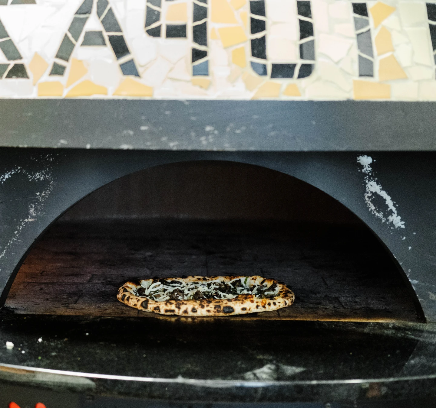 Pizza cooking in Gatto Pazzo's oven