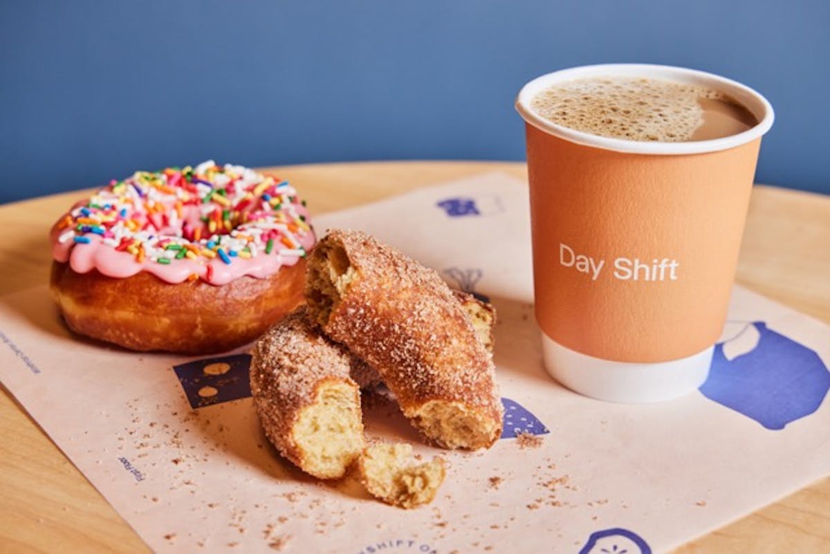 a cup of coffee and a donut on a plate