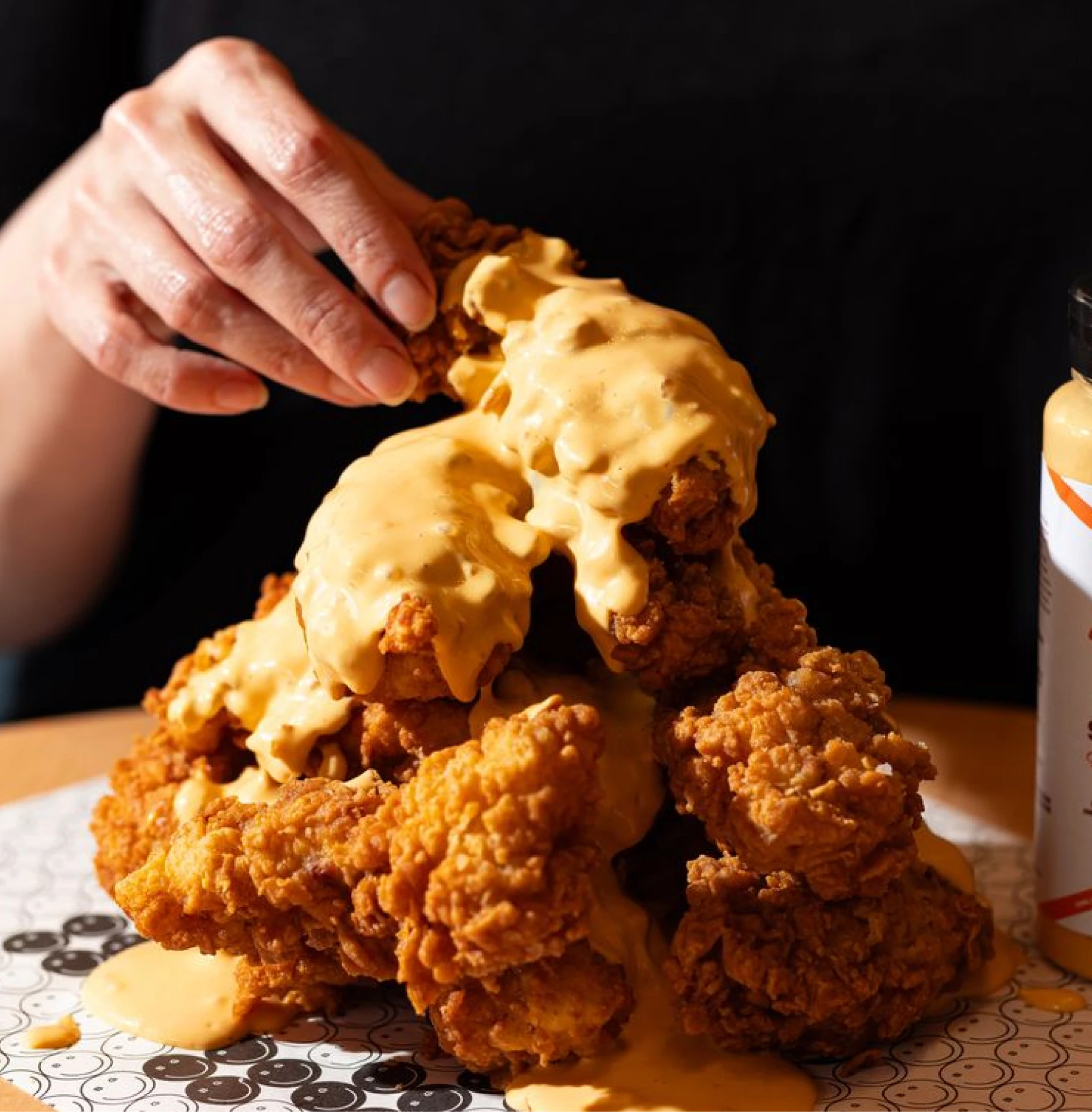 Fried chicken stacked up with melted cheese dripping on top