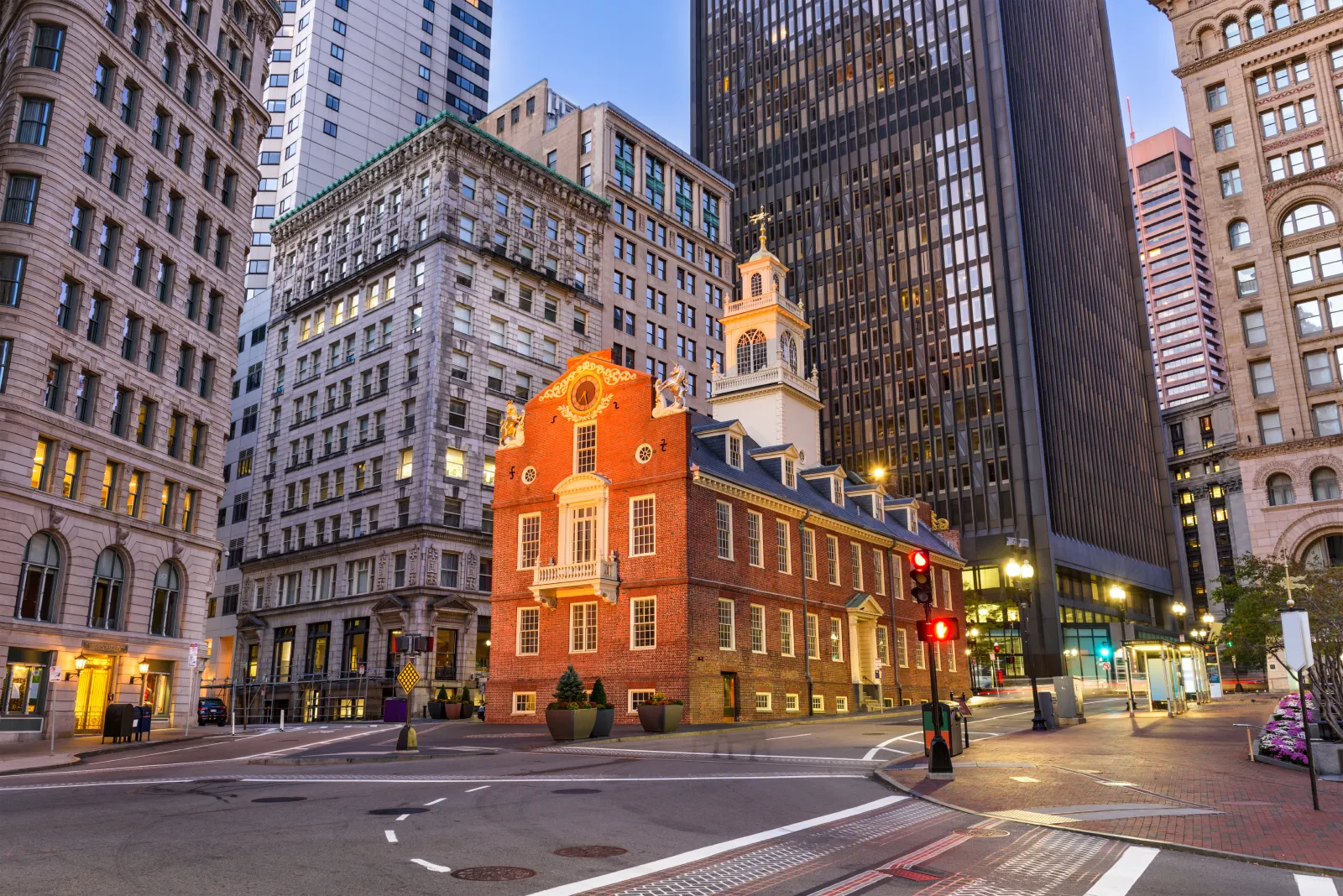 Old State House in Boston Financial District surrounded by modern skyscrapers at dusk in downtown Boston.
