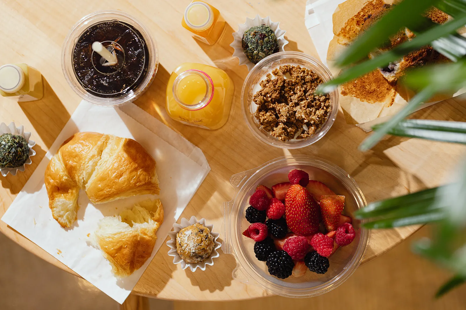 Croissant, fresh berries, granola, juice, and coffee spread across a table for lunch in Boston.