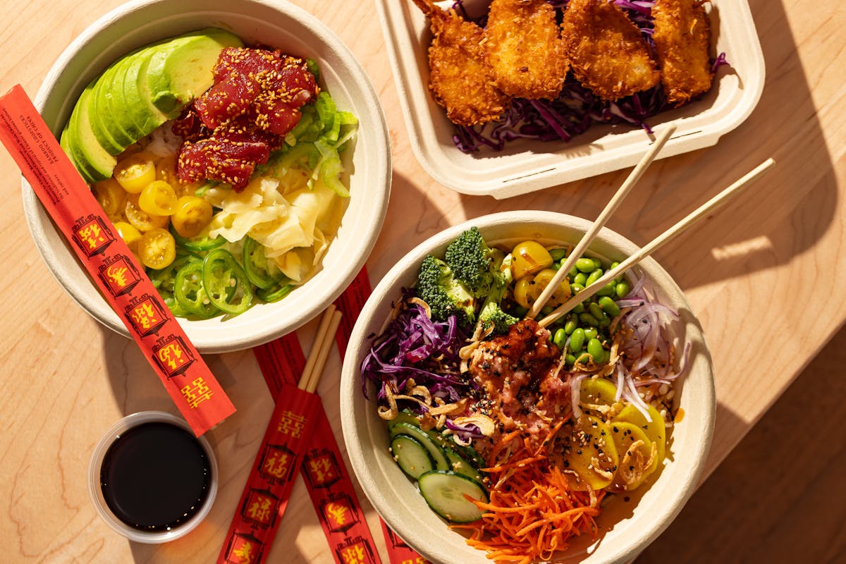 Overhead shot of a two poke bowls and a Hawaiian lunch plate.