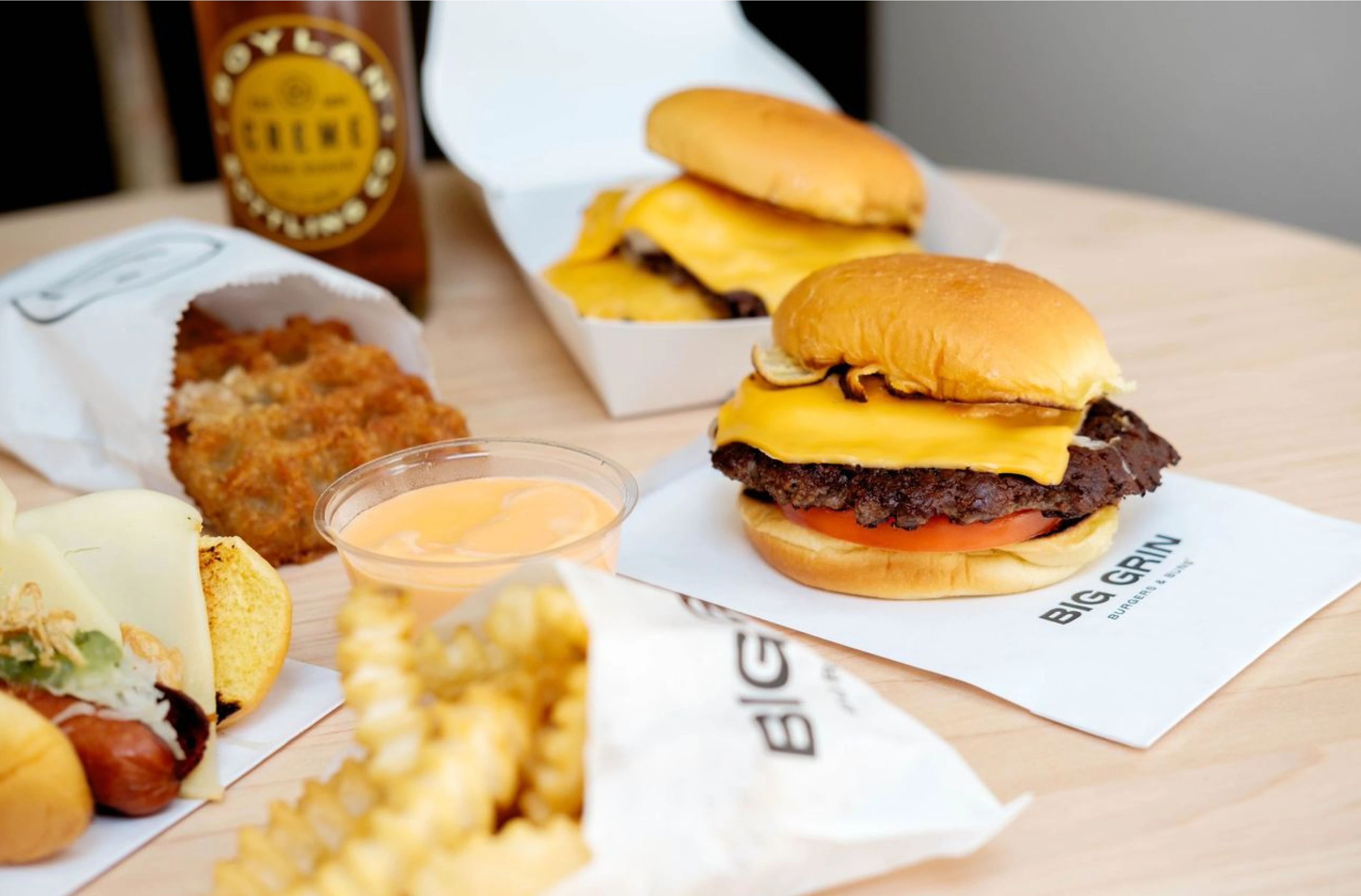 Closeup image of hamburgers, french fries and dipping sauces