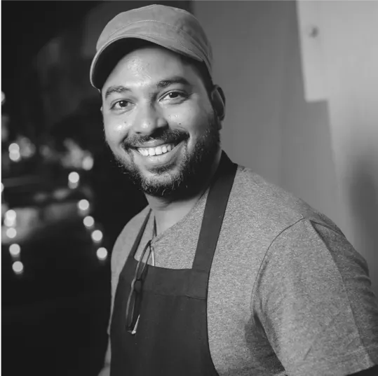 a man wearing a hat and smiling at the camera