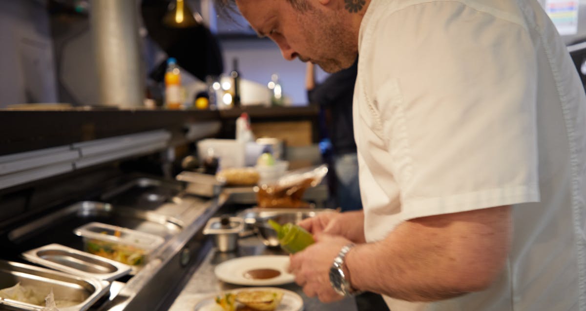 a man cooking in a kitchen preparing food