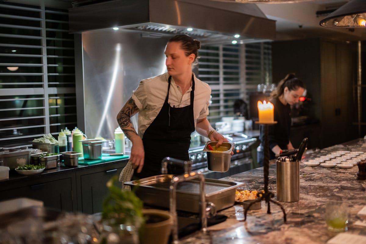 a man and woman preparing food in a kitchen