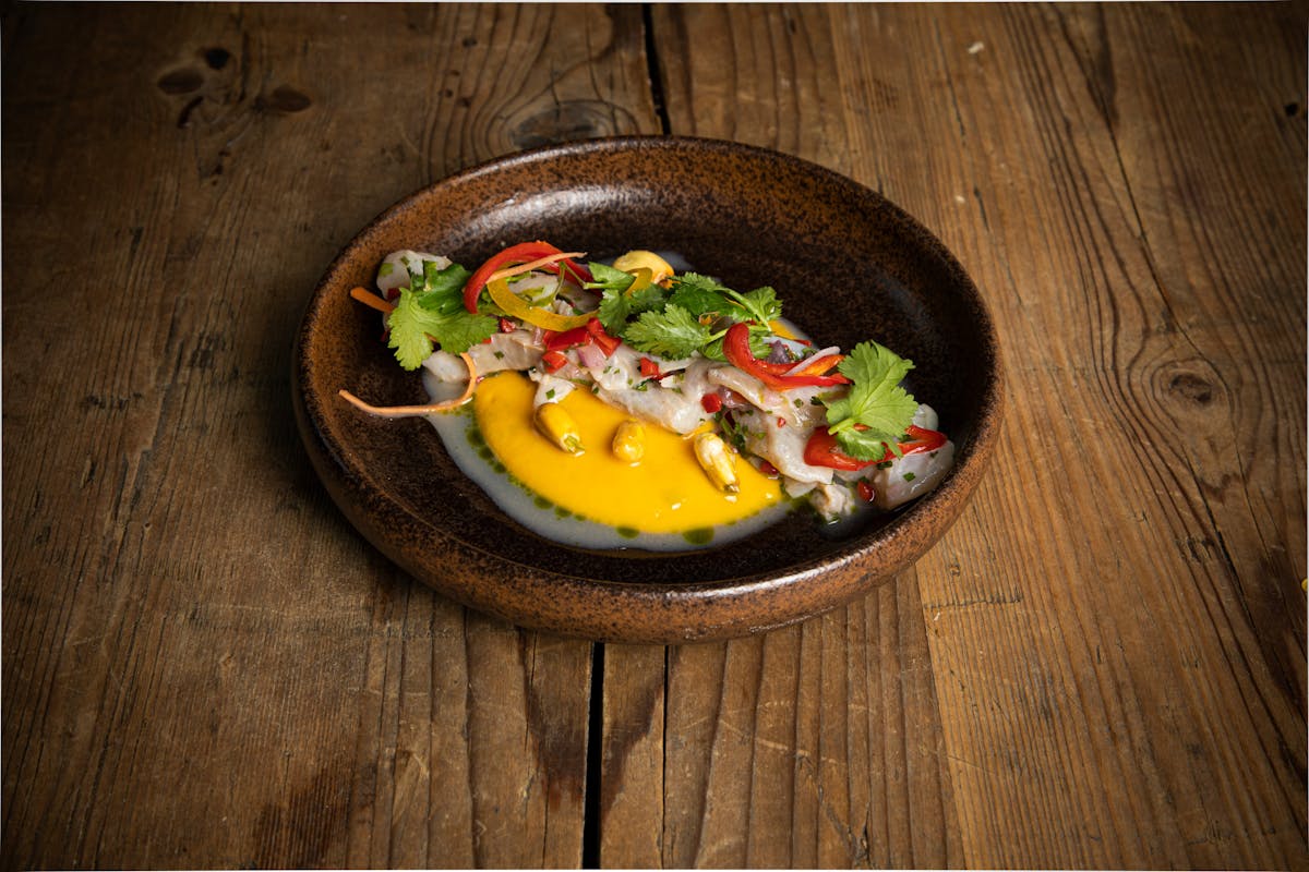 a bowl of food sitting on top of a wooden table