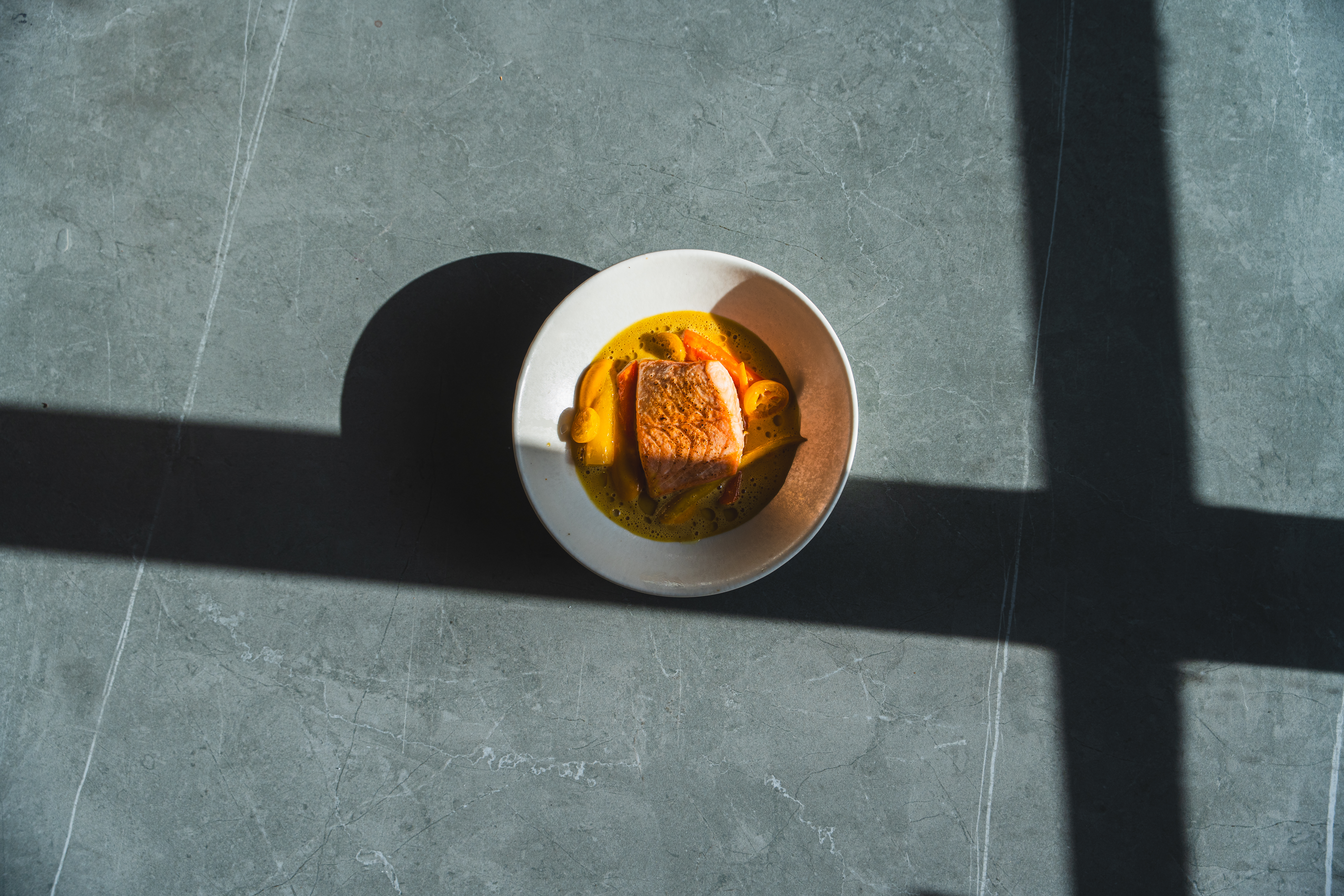 a bowl of soup with fish and vegetables