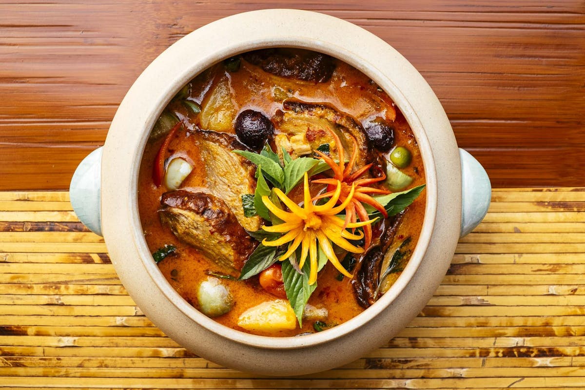 a bowl of food sitting on top of a wooden table