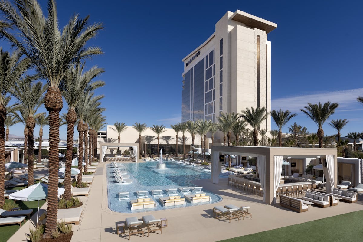 a pool and daybeds and durango casino resort in the background of the image