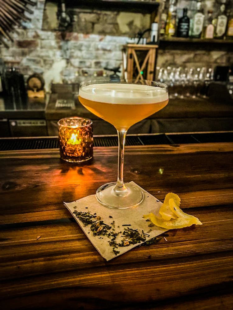 a glass of wine sitting on top of a wooden table